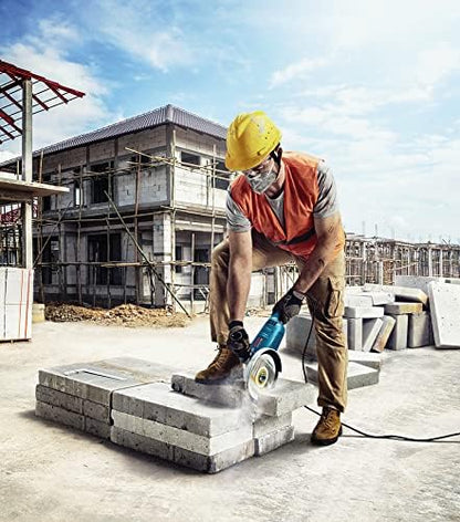 Worker using a circular saw on a concrete block at a construction site.